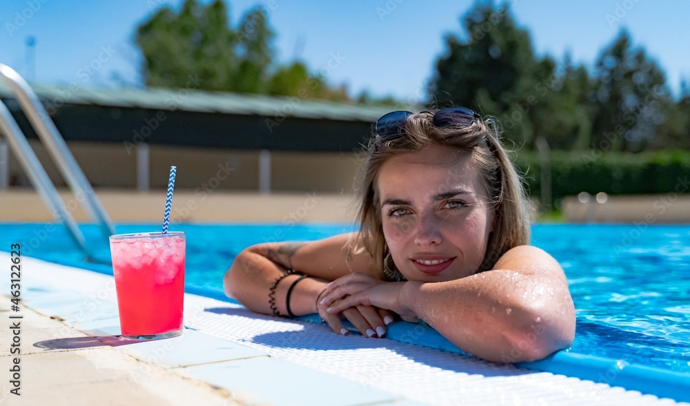 Young girl enjoying a cold drink in the pool.