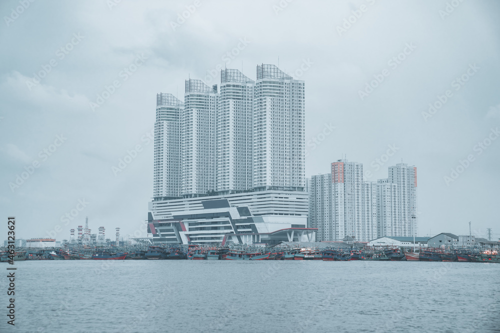Beautiful view of tall skyscrapers on the seashore in Jakarta city, Indonesia on a gloomy day - obrazy, fototapety, plakaty 