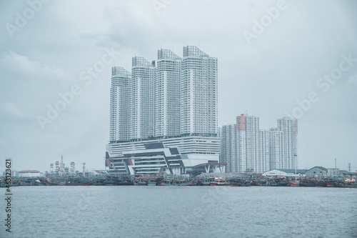 Beautiful view of tall skyscrapers on the seashore in Jakarta city, Indonesia on a gloomy day