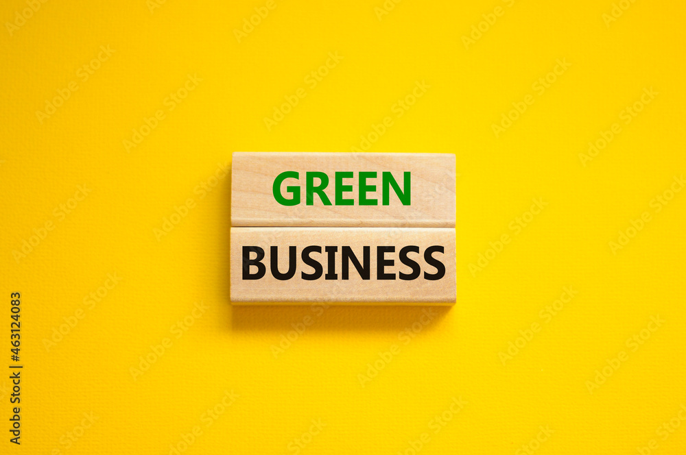 Time to green business symbol. Wooden blocks with words 'Green business'. Beautiful yellow background. Green success business ecology concept. Copy space. Time to green business symbol. Wooden blocks with words 'Green business'. Beautiful yellow background. Green success business ecology concept. Copy space.