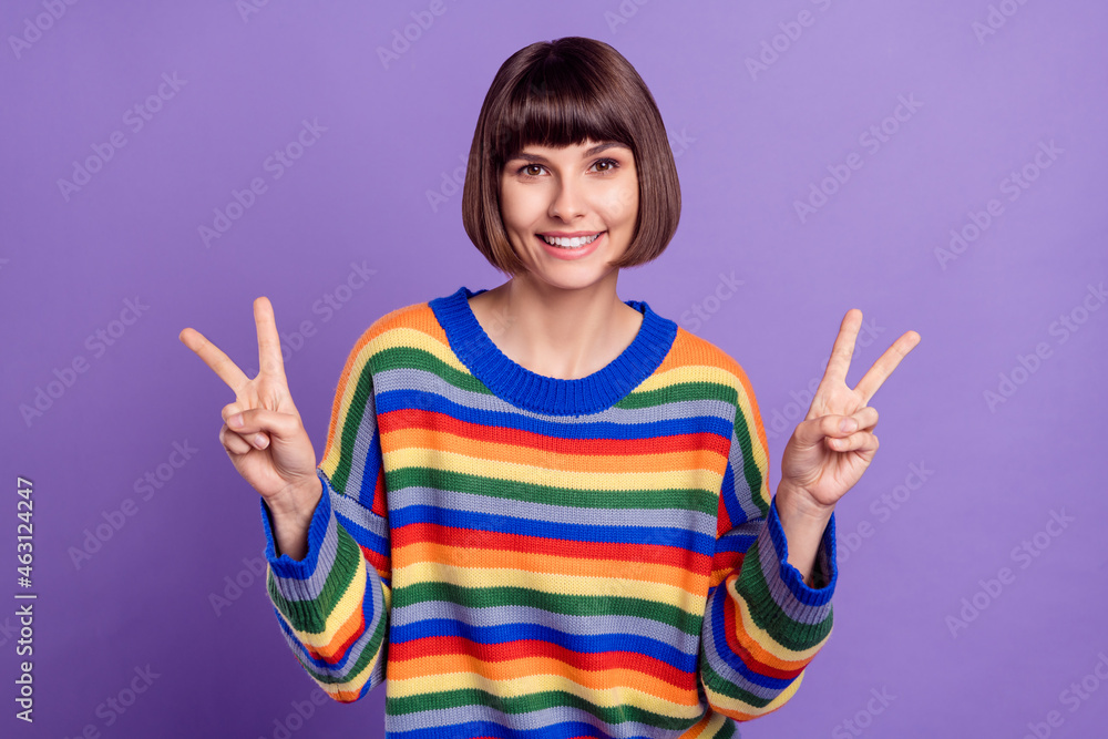 Photo of friendly charming lady bangs hairdo show v-sign wear striped sweater isolated purple color background Photo of friendly charming lady bangs hairdo show v-sign wear striped sweater isolated purple color background