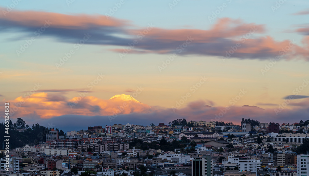 Long exposure cityscape of Quito at sunset with Cayambe volcano, Ecuador.