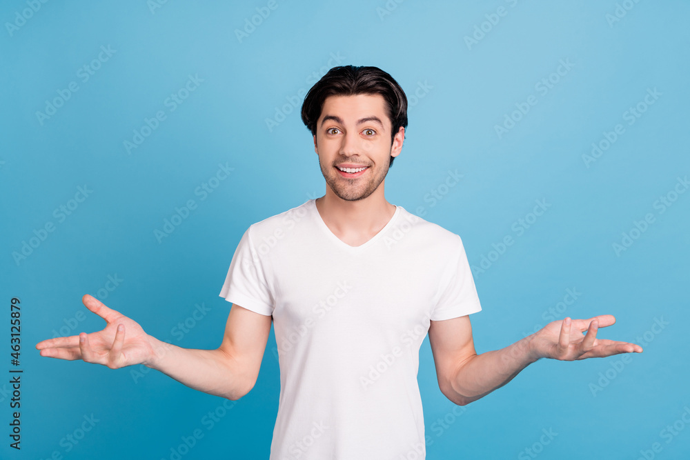 Photo of cheerful hospitable guy open hands welcome invitation wear white t-shirt isolated blue color background Photo of cheerful hospitable guy open hands welcome invitation wear white t-shirt isolated blue color background