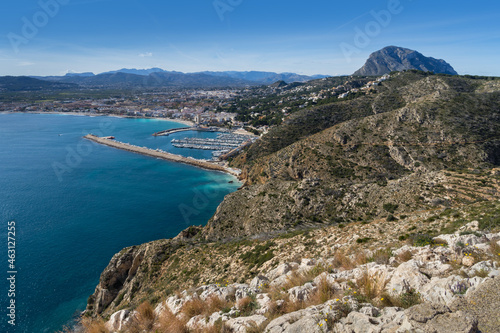 View of the blue mediterranean sea and a port of a coastal city and a beautiful mountain landscape in Spain