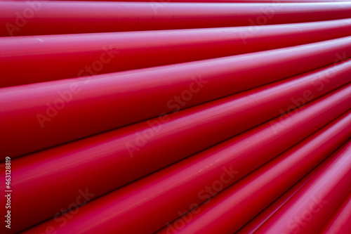Red PVC plastic pipes for pipelines and optical cables to use as a background for the design. Diminishing perspective
