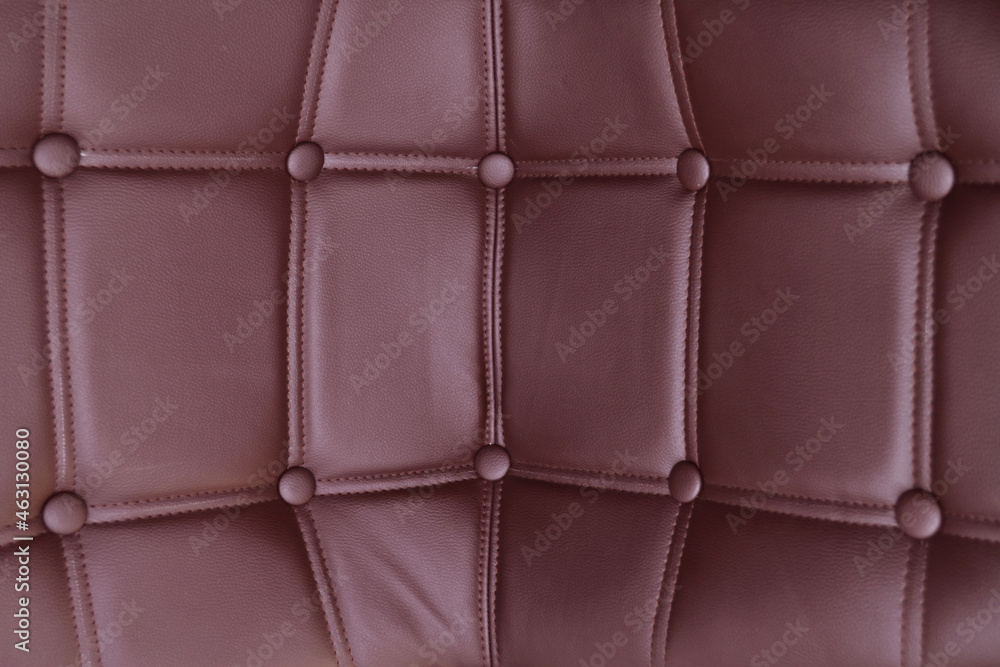 Corner background of a brown leather sofa or armchair covered with leather buttons. The texture of a vintage Chesterfield sofa. Corner background of a brown leather sofa or armchair covered with leather buttons. The texture of a vintage Chesterfield sofa.