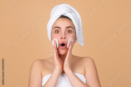 Excited beautiful woman with clean skin. Girl beauty face care. Facial treatment. Spa skin care, beauty woman wearing hair towel after beauty treatment. Beautiful perfect skin, isolated beige.