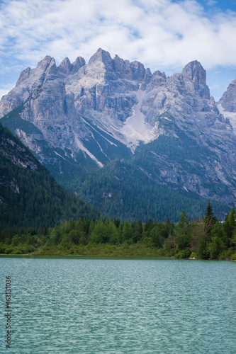 A majestic view of Durrensee lake in Italy surrounded by beautiful forested mountains in the Dolomites at summer