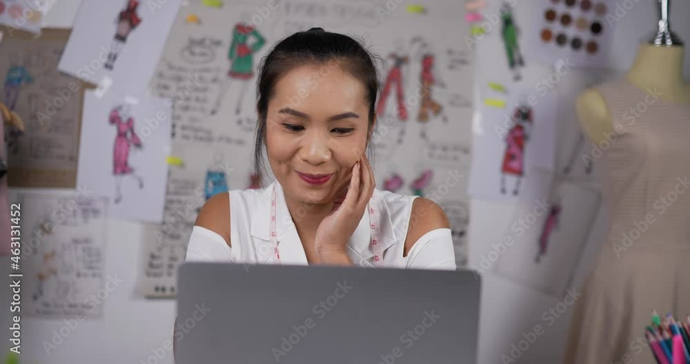 Woman designer contemplating drawings via laptop Woman designer contemplating drawings via laptop