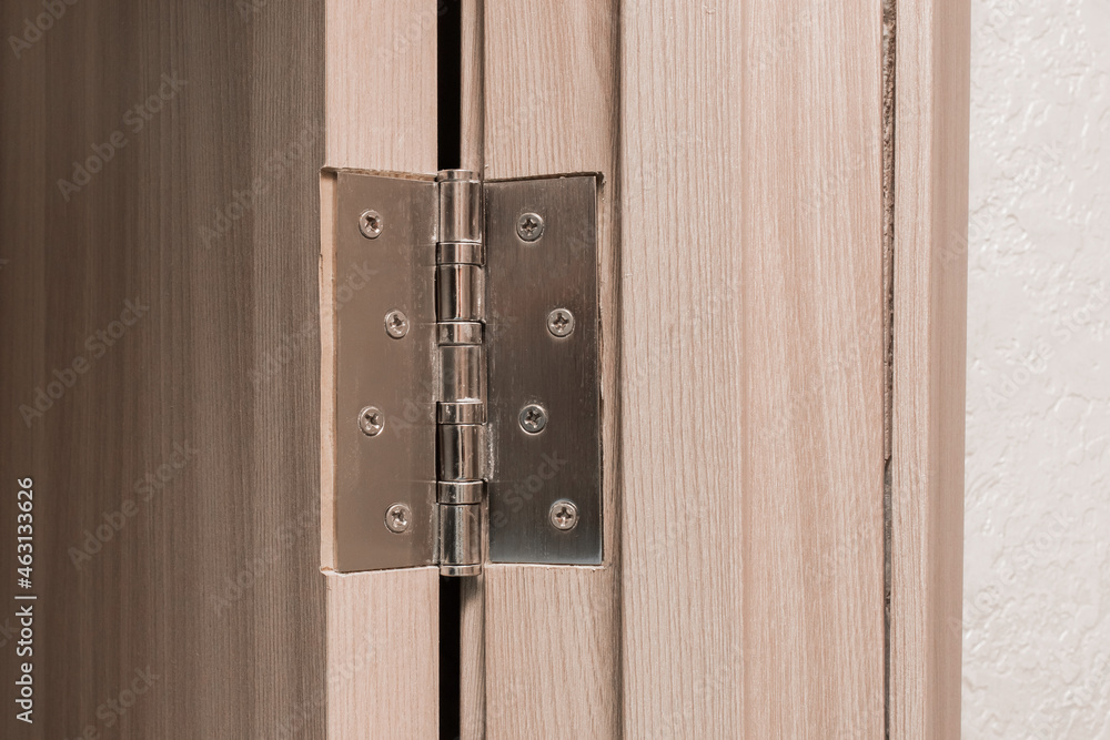 Obraz premium Wooden door opening metal door hinge, close-up