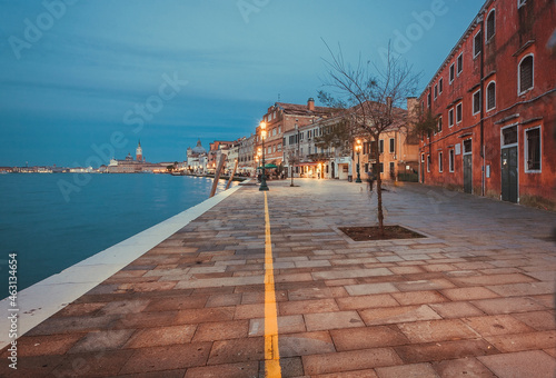 Night scene with people in motion blur and historical island of Giudecca