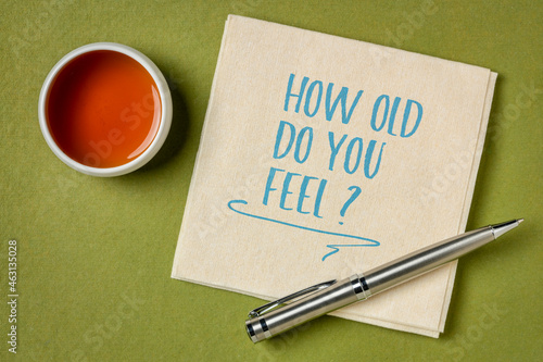 How old do you feel? Handwriting on a napkin with a cup of tea. Aging, feelings and mindset concept.