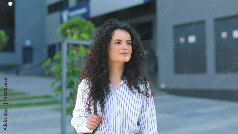 Portrait of beautiful lovely cheerful caucasian girl on urban city streets. Outdoors young attractive woman smiling to the camera while standing with backpack Portrait of beautiful lovely cheerful caucasian girl on urban city streets. Outdoors young attractive woman smiling to the camera while standing with backpack