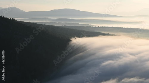 Tranquil scene of morning haze clouds clowly drifting in a valley. Scenery time lapse of natural clouds in mountains photo