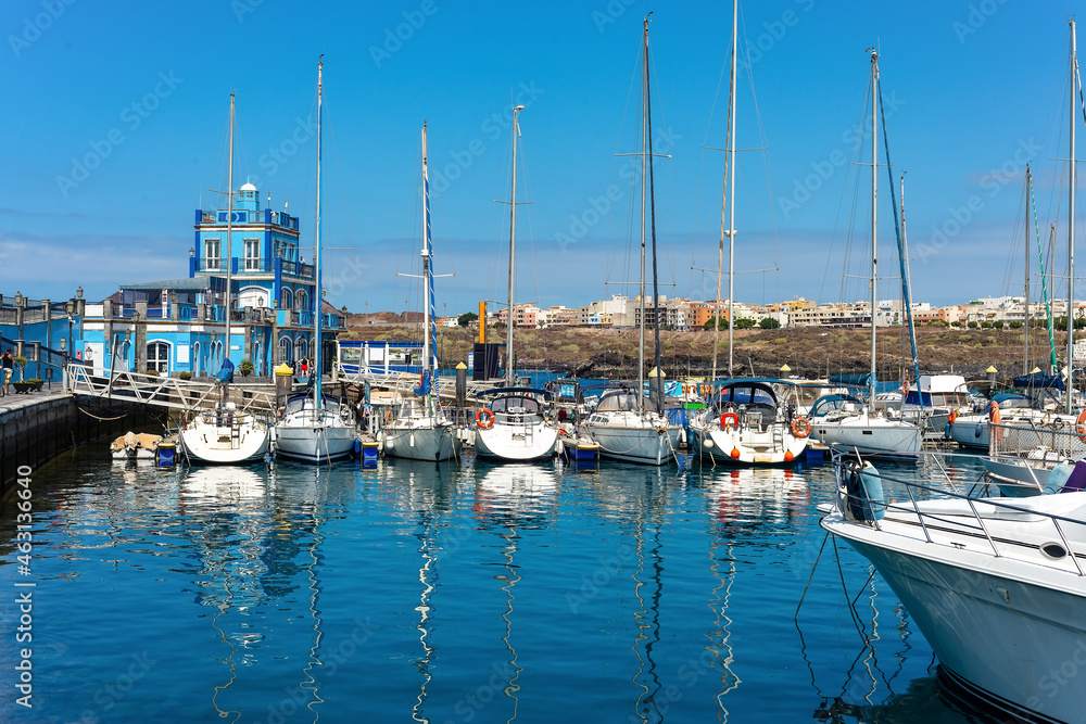 Las Galletas port with fishing boats with the City in the background. In Tenerife. Canary Islands. Spain