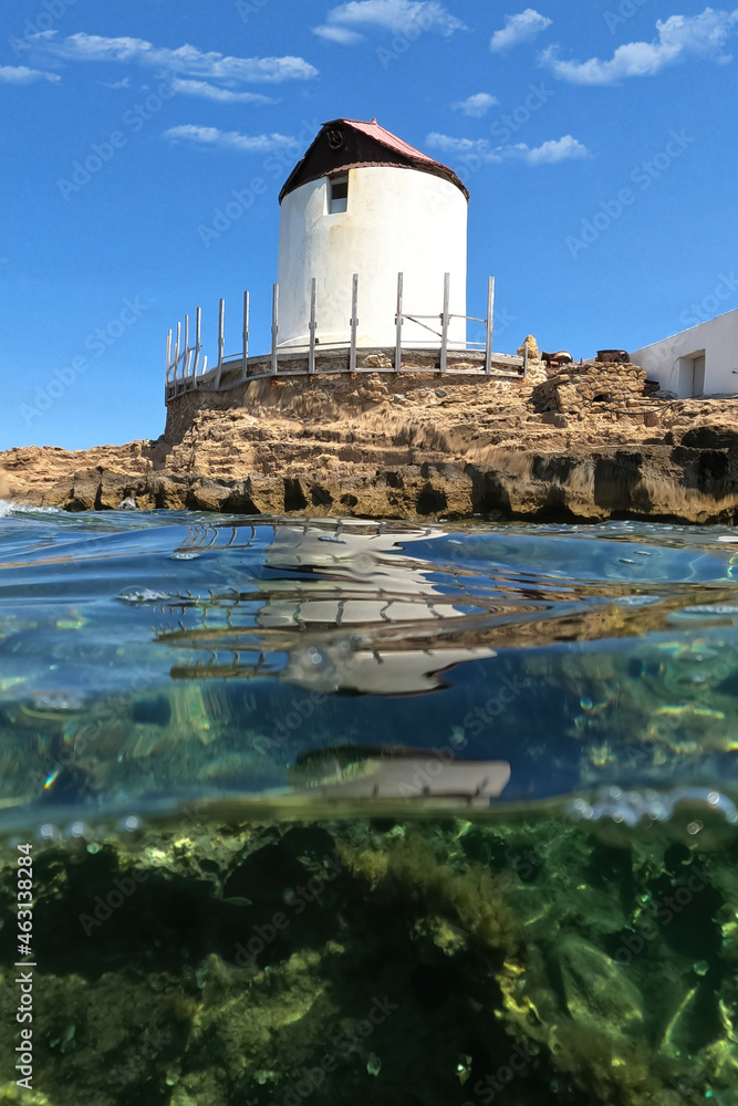 Underwater split photo of traditional windmill in Molos area next to famous church and islet of Agios Ermolaos, Skiros island, Sporades, Greece