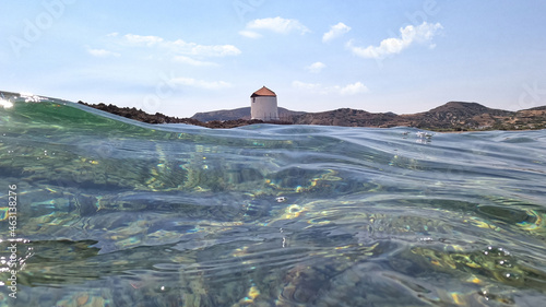 Underwater split photo of traditional windmill in Molos area next to famous church and islet of Agios Ermolaos, Skiros island, Sporades, Greece photo