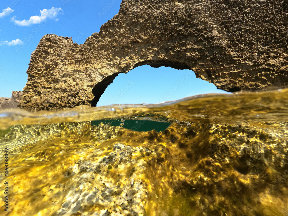 Underwater split photo of iconic rock formations in Pouria beach an old stone factory, Skyros island, Sporades, Greece