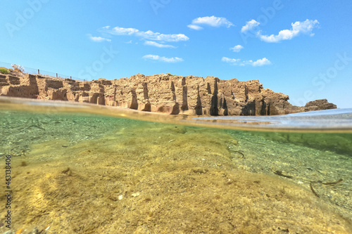 Underwater split photo of iconic rock formations in Pouria beach an old stone factory, Skyros island, Sporades, Greece photo