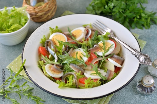 Salad with potatoes, eggs, tomatoes, arugula and anchovies.