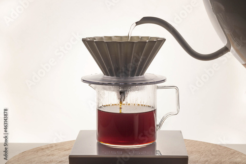 Gooseneck kettle pouring into a coffee dripper photo