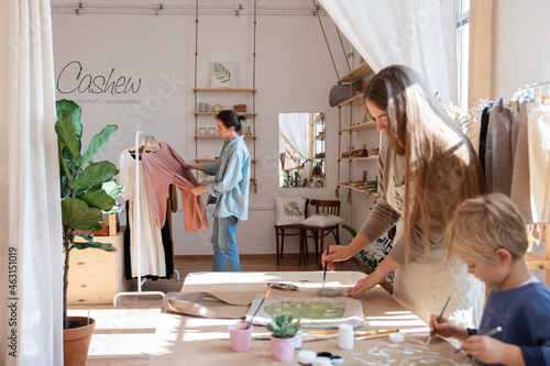 Woman choosing dress near artisan photo