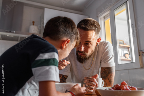 Father speaking with son having breakfast