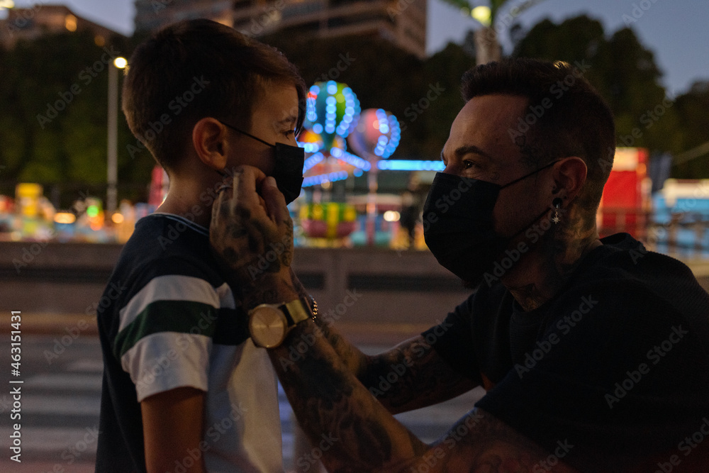 Father adjusting mask on son Father adjusting mask on son