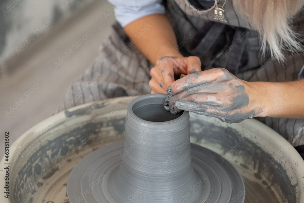 Crop potter shaping brim of vase Crop potter shaping brim of vase