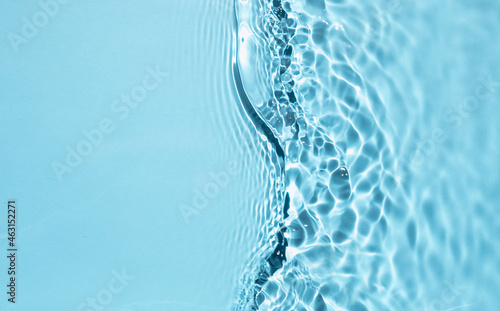 Trendy summer nature banner. Defocused blue liquid colored clear water surface texture with splashes bubbles with copy space. Water waves in sunlight background. 