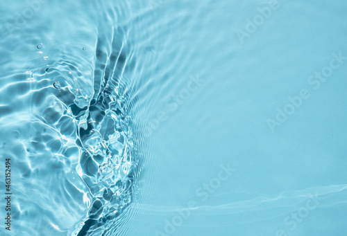 Trendy summer nature banner. Defocused blue liquid colored clear water surface texture with splashes bubbles with copy space. Water waves in sunlight background. 