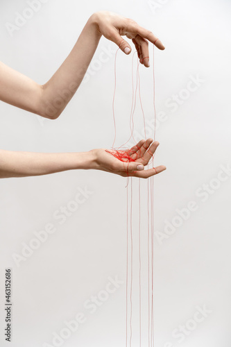 Woman's hand with red threads which symbolized control and manipulation photo