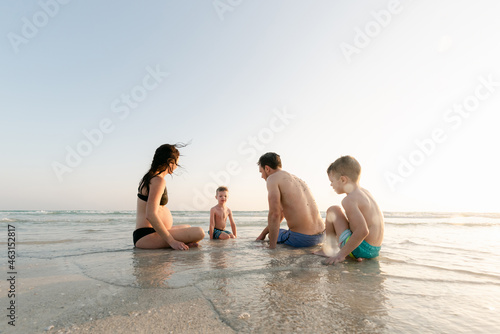 Family of four sitting in the water photo