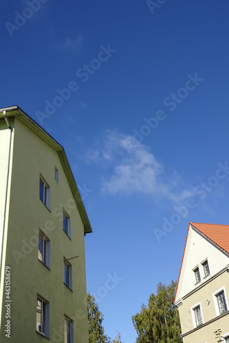 Close up of the yellow houses. Clear blue sky background with some autumn foliage on the back. Bottom up view. Pelgulinna, Tallinn, Estonia, Europe. September 2021 photo