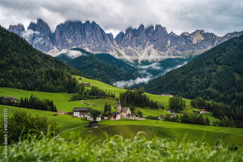 St Magdalena church in Val di Funes valley, Dolomites, Italy. Furchetta and Sass Rigais mountain peaks in background photo