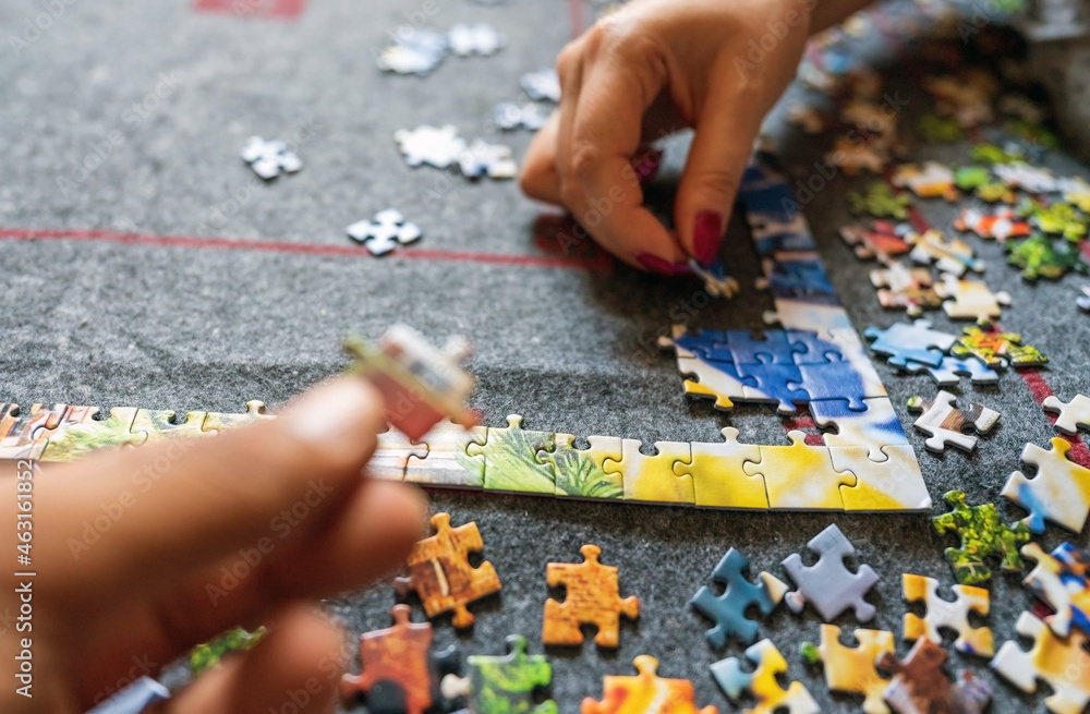 Hand giving support by giving a piece of puzzle, connecting jigsaw together. Group project concept. success and strategy and partner concept