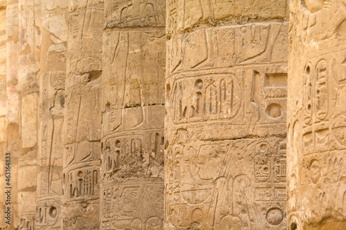 Ancient columns in a row with carved egyptian hieroglyphics 