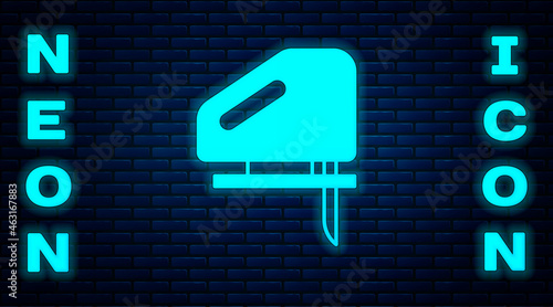 Glowing neon Electric jigsaw with steel sharp blade icon isolated on brick wall background. Power tool for woodwork. Vector