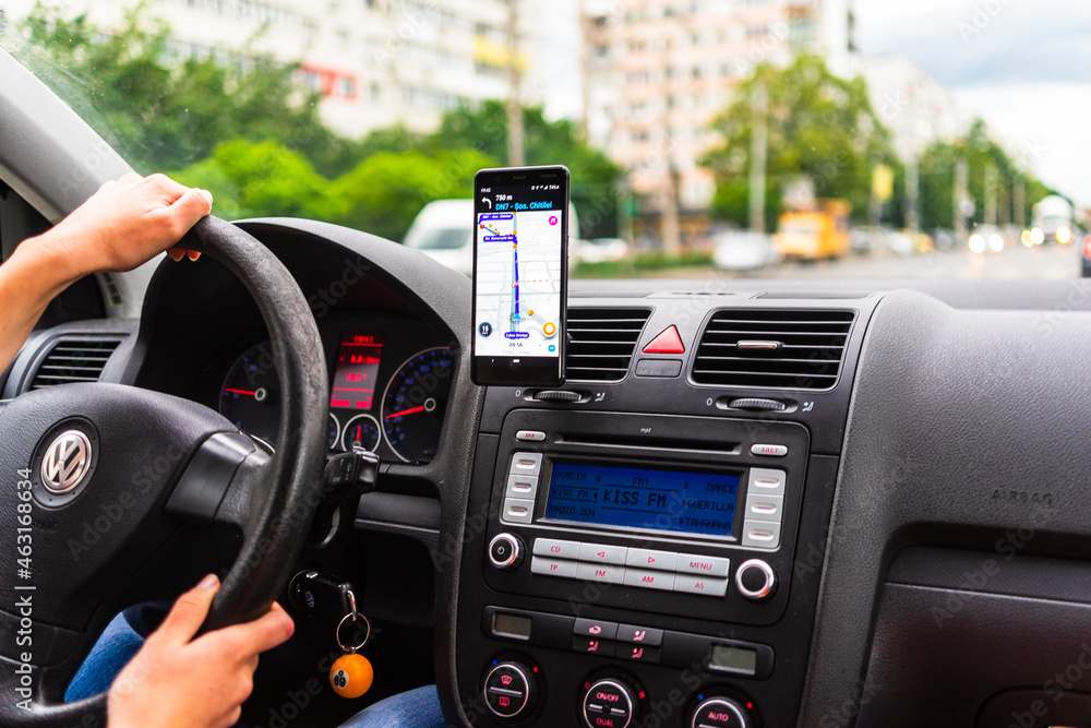 Driving and using waze maps application on smartphone on car dashboard ...