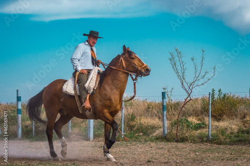 Argentine cowboy (gaucho) walks his horse past camera, in Patagonia. photo