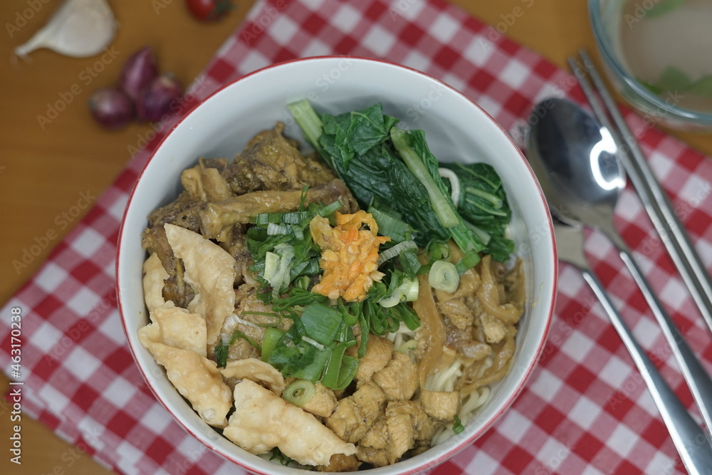mie ayam or chicken noodle and wooden chopsticks indonesian food with toped chicken filet and meatball on the wood table front angle with property mie ayam or chicken noodle and wooden chopsticks indonesian food with toped chicken filet and meatball on the wood table front angle with property