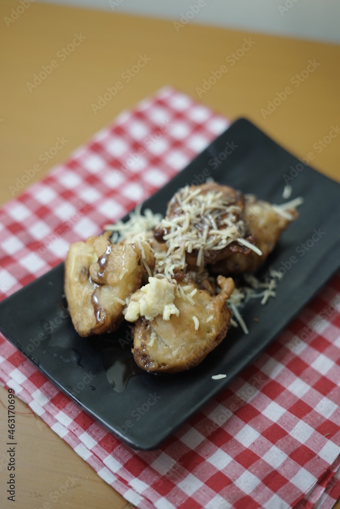 Fried banana topping chocolate, milk and cheese. Popular snack in Indonesia. Fried banana topping chocolate, milk and cheese. Popular snack in Indonesia.