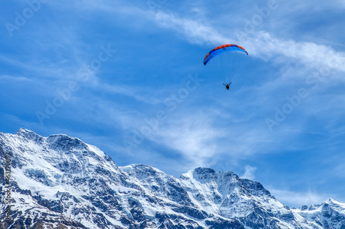 Paraglider in the blue sky. The sportsman flying on a paraglider. Leisure sports activity in holiday