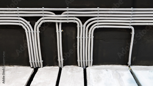 Fotografie Electrical cables and pipes on house concrete ceiling, modern wiring