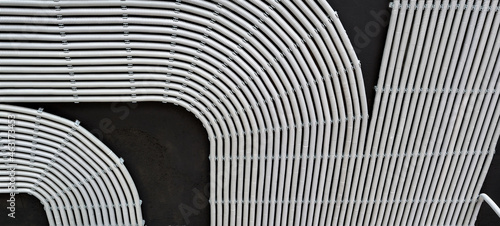 фотографія Electrical cables and pipes on house concrete ceiling, background