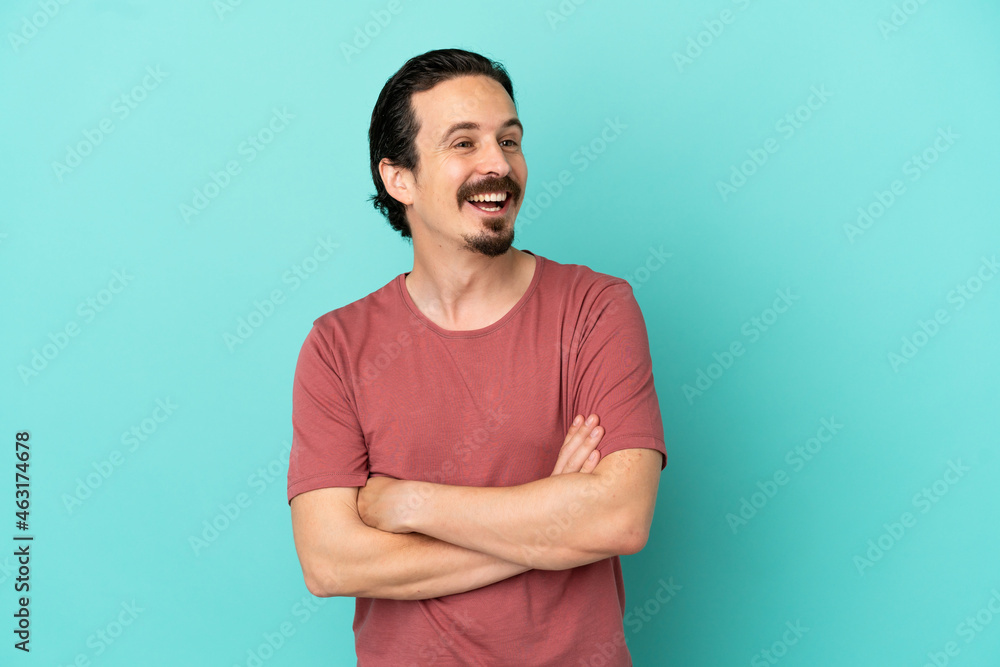 Obraz premium Young caucasian man isolated on blue background happy and smiling