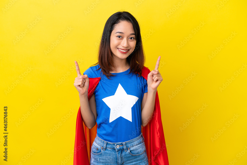 Super hero Vietnamese woman isolated on yellow background pointing up a great idea Super hero Vietnamese woman isolated on yellow background pointing up a great idea