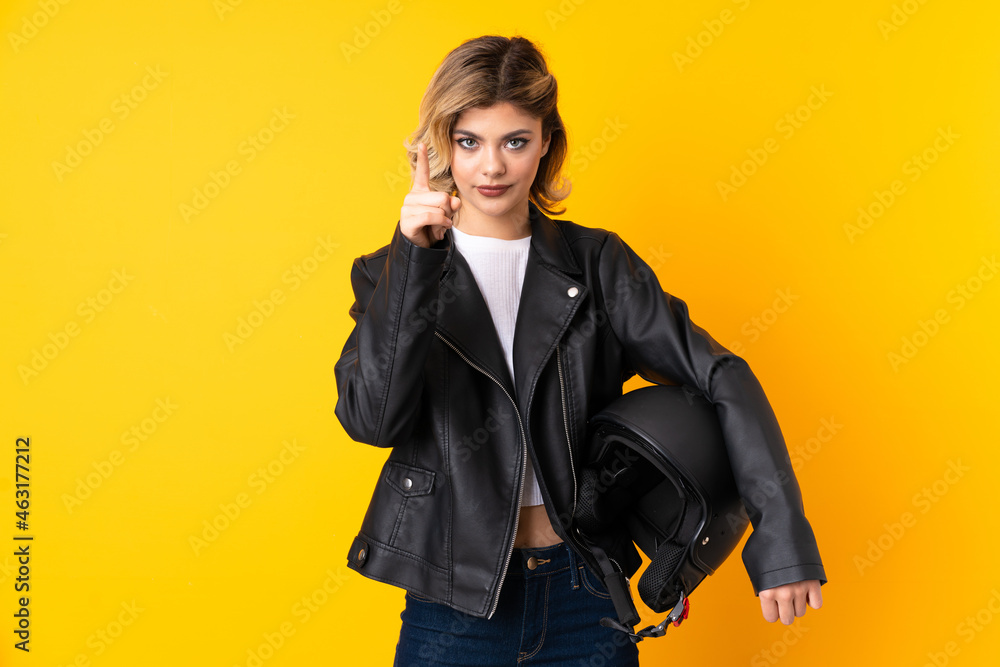 Teenager woman holding a motorcycle helmet isolated on yellow background touching on transparent screen Teenager woman holding a motorcycle helmet isolated on yellow background touching on transparent screen