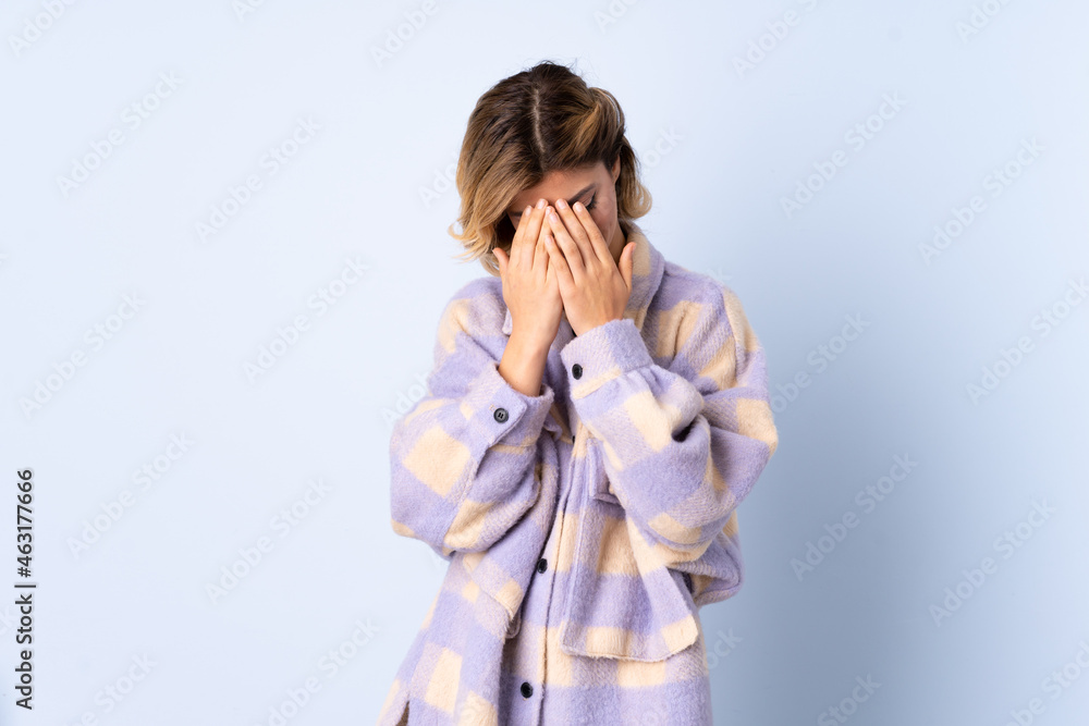 Young Russian woman isolated on blue background with tired and sick expression Young Russian woman isolated on blue background with tired and sick expression