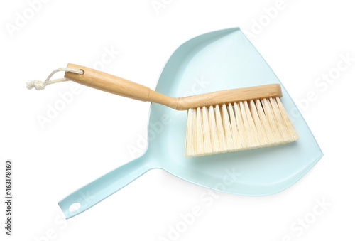 Light blue dustpan and wooden brush on white background  top view